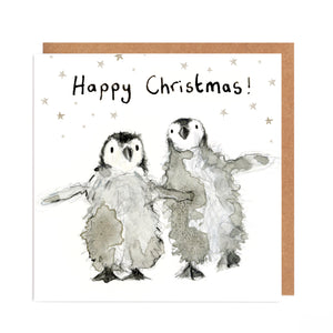 Square white Christmas card featuring watercolour and pencil illustration of a two fluffy baby penguins surrounded by stars, and handwritten 'Happy Christmas!' message.