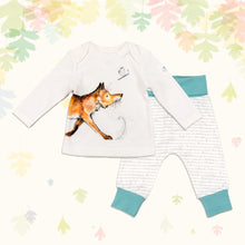 Load image into Gallery viewer, Baby gift set comprising a white long-sleeved top featuring an illustrated wraparound fox print and matching bottoms with blue cuffs, on a backdrop of pastel leaves. 