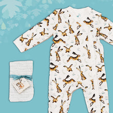 Load image into Gallery viewer, Baby gift set comprising a white babygrow featuring an illustrated hare and dragonfly print and matching dribble cloths tied in turquoise ribbon, on a blue backdrop with decorative  leaves. 