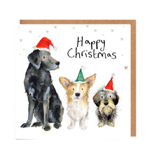 Load image into Gallery viewer, Square white Christmas card featuring watercolour and pencil illustrations of three dogs, a labrador, a corgie and a wire haired dachshund wearing Christmas hats, surrounded by stars and handwritten &#39;Happy Christmas&#39; message.