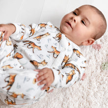 Load image into Gallery viewer, One year old baby wearing dexter fox printed babygrow lying on his back smiling. 