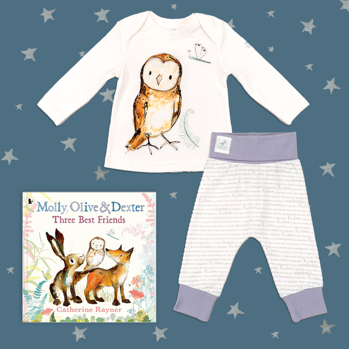 Baby gift set featuring a book from the Molly, Olive and Dexter series by Catherine Rayner, 'Three Best Friends', and a matching owl pyjama set laid on a midnight blue backdrop with silver stars. The pyjama set comprises a white long-sleeved top featuring an illustrated wraparound owl print and matching bottoms with purple cuffs.