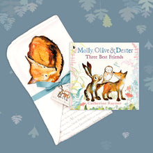 Load image into Gallery viewer, Baby gift set featuring a book from the Molly, Olive and Dexter series by Catherine Rayner, &#39;Three Best Friends&#39;, and a matching fox blanket laid on a dusty blue backdrop with pastel leaves. The blanket has a hood featuring a fox curled up for sleep and is wrapped with a turquoise ribbon. 