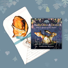 Load image into Gallery viewer, Baby gift set featuring a book from the Molly, Olive and Dexter series by Catherine Rayner, &#39;Who&#39;s Afraid of the Dark?&#39;, and a matching fox blanket laid on a dusty blue backdrop with pastel leaves. The blanket has a hood featuring a fox curled up for sleep and is wrapped with a turquoise ribbon. 