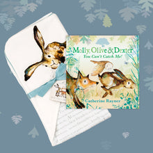 Load image into Gallery viewer, Baby gift set featuring a book from the Molly, Olive and Dexter series by Catherine Rayner, &#39;You Can&#39;t Catch Me!&#39;, and a matching hare blanket laid on a dusty blue backdrop with pastel leaves. The blanket has a hood featuring Molly Hare and is wrapped with a turquoise ribbon. 