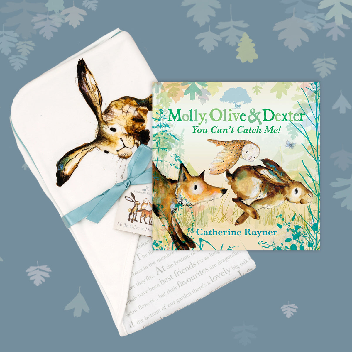 Baby gift set featuring a book from the Molly, Olive and Dexter series by Catherine Rayner, 'You Can't Catch Me!', and a matching hare blanket laid on a dusty blue backdrop with pastel leaves. The blanket has a hood featuring Molly Hare and is wrapped with a turquoise ribbon. 