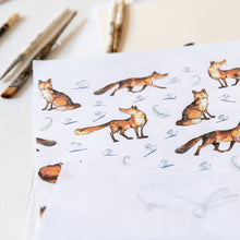 Load image into Gallery viewer, Close up of the Dexter fox repeat print beside some paintbrushes and pencils. 