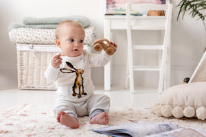 One year old baby sat up wearing the Molly Hare top and matching story-time joggers with dusky heather purple trim. 