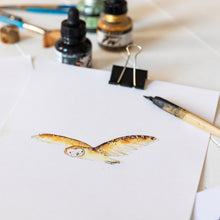 Load image into Gallery viewer, Illustration of olive owl on cream paper alongside ink bottles, paint brushes and a dip pen. 