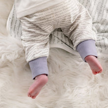 Load image into Gallery viewer, Close-up on a baby wearing Dusky heather storytime joggers, showing the story text print and dusky heather cuffs. 