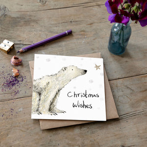 Christmas card featuring illustration of Paddy Polar Bear laid flat on a wooden table with a matching brown envelope. 