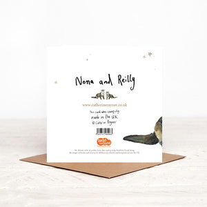 Christmas card stood on matching brown envelope, showing reverse side of Nona and Reilly Otters Christmas card, featuring details of Christmas charity partner children's literacy charity Read for Good. 